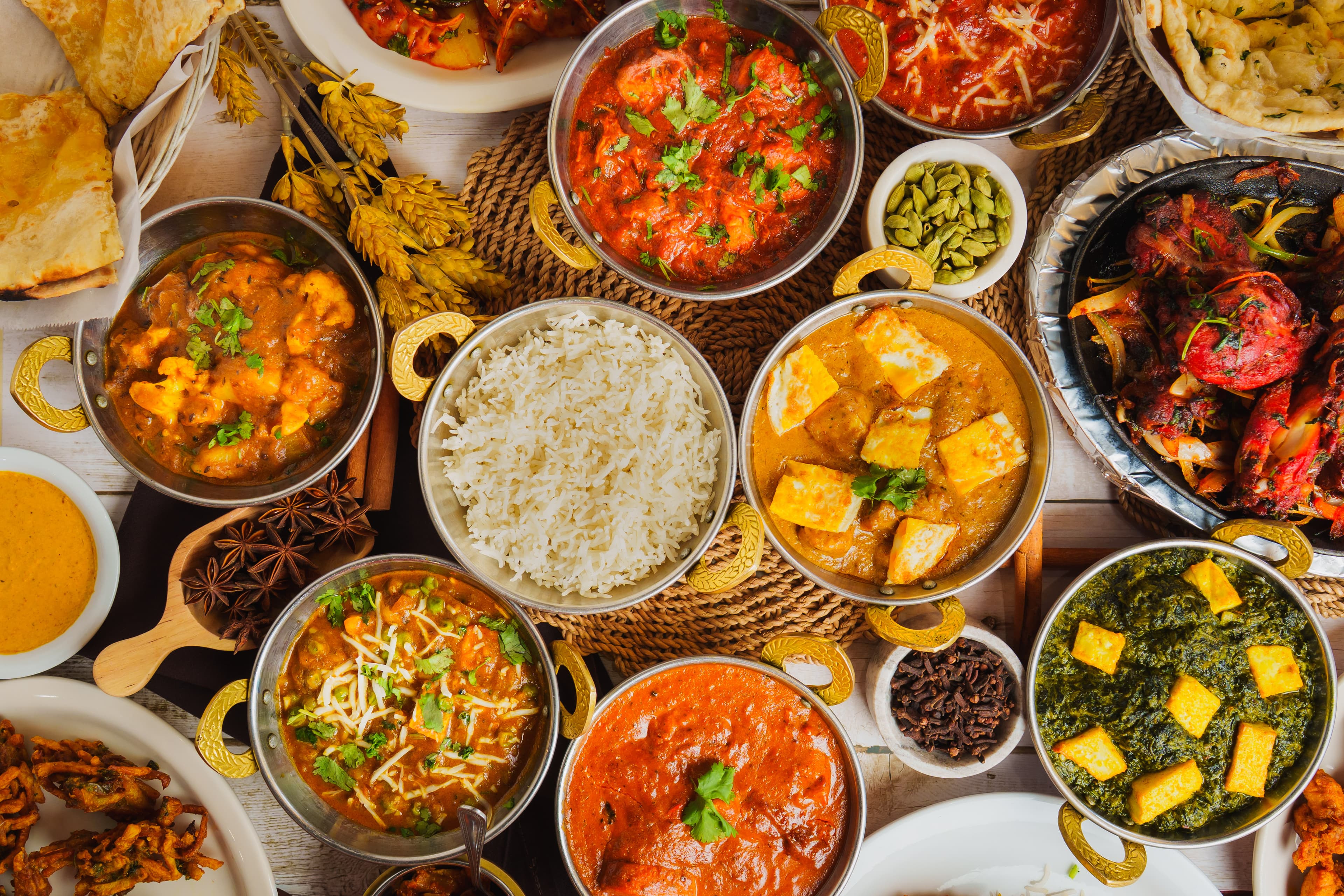 Indian cuisine spread with various dishes including tandoori chicken, naan, and curry dishes